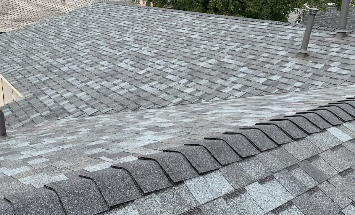 Finished gray architectural-shingle roof with ridge caps and pipe penetrations