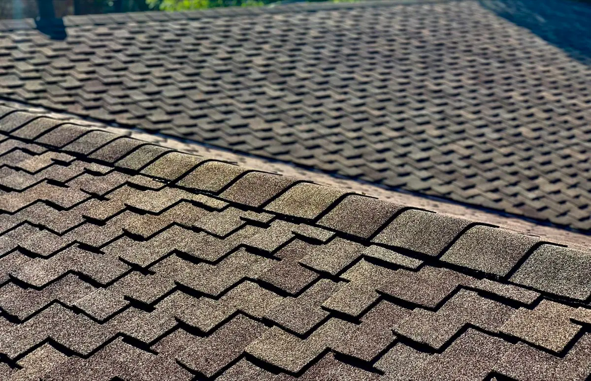 Close view of laminated asphalt shingles and a ridge-cap line