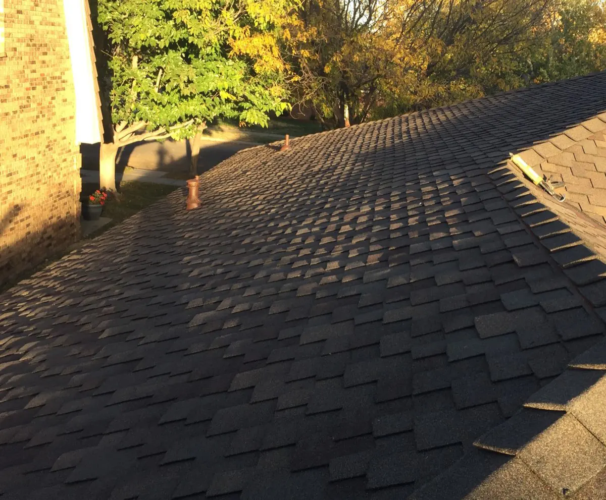 Brown asphalt-shingle roof field with adjoining hip and ridge lines